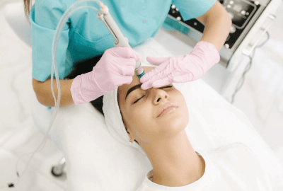 Esthetician performing hydrobermabrasion on female client at Bewitching